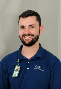 Smiling man with a beard wearing a blue polo